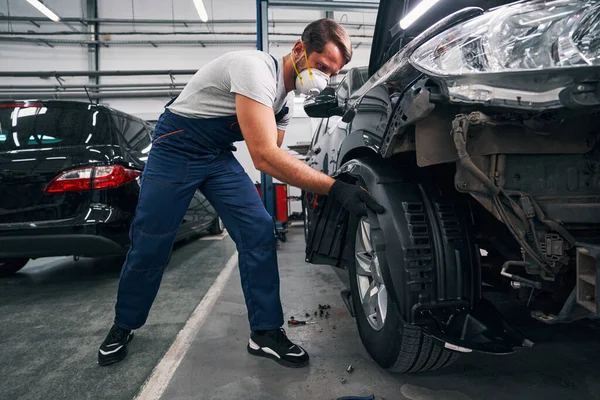 Mecánico de coche está retirando la cubierta del arco de rueda —  Fotos de Stock