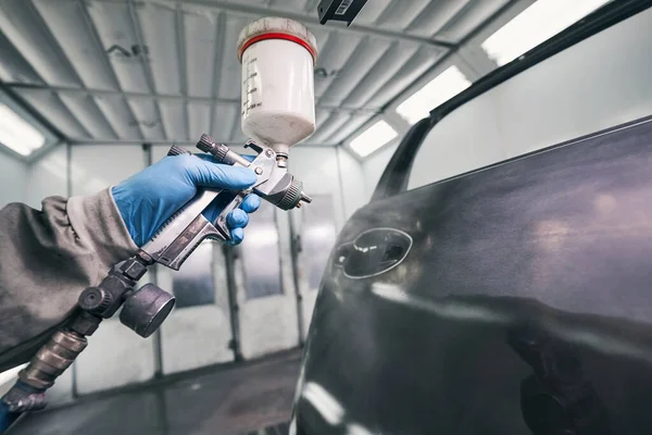 Auto oficina trabalhador pintura porta do carro com pistola de pulverização — Fotografia de Stock
