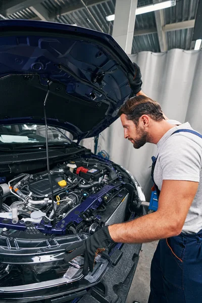 Erős szerelő, motorháztető alatti autóalkatrészeket vizsgál — Stock Fotó