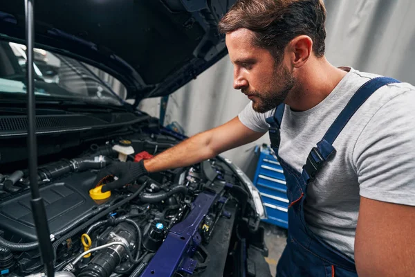 Reparador abriendo una tapa para el control de aceite del motor —  Fotos de Stock