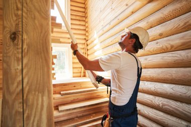 Tahta tahtayı merdiven duvarına yapıştıran adam.