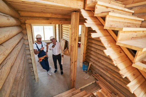 Stavební inženýr s kapesním rádiem dává pokyny pro pozitivní housebuilder — Stock fotografie