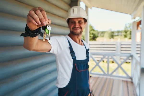 家に鍵を引き渡す建設労働者 — ストック写真