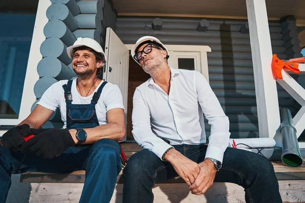 Twee mannen kijken naar iets vanaf de trap van het huis veranda — Stockfoto