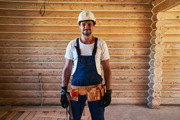 Manlig byggmästare står inne i trä hus — Stockfoto