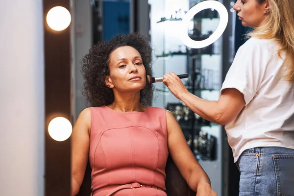 Delighted curly haired female being in beauty salon — Stock Photo, Image