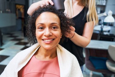 Kameraya bakan neşeli esmer kadın.