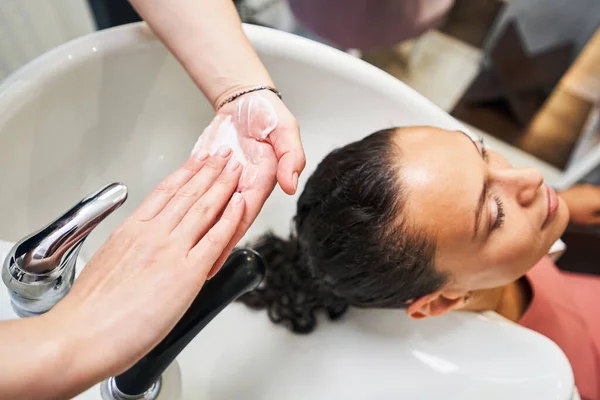 Mestre competente usando bálsamo para alisar o cabelo — Fotografia de Stock