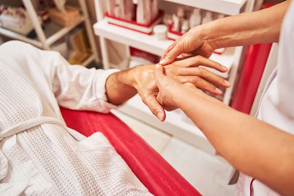 Schoonheidsspecialist kneden mannelijke hand in spa salon — Stockfoto