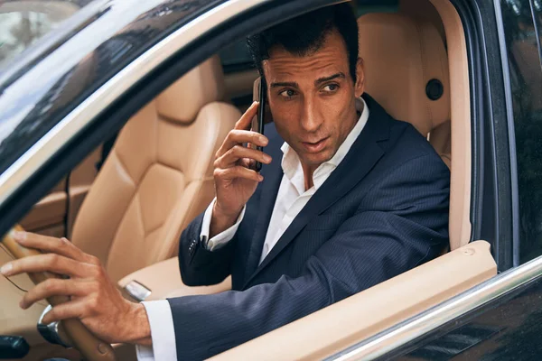 Empresario sentado en coche y hablando por teléfono — Foto de Stock