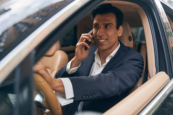 즐거이 일하는 사업가가 자동차로 전화를 받다 — 스톡 사진