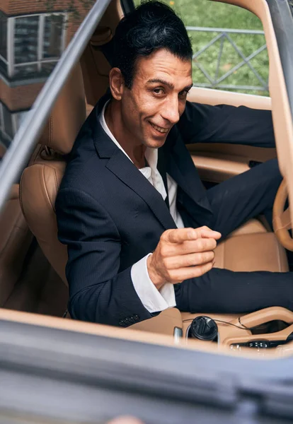 Hombre alegre en el automóvil señalando con el dedo a la cámara — Foto de Stock