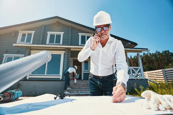 Geconcentreerde huisbouwer maakt notities over de indeling van het huis — Stockfoto