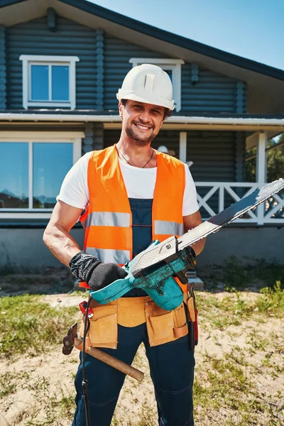 Šťastný stavební dělník s motorovou pilou v rukou — Stock fotografie