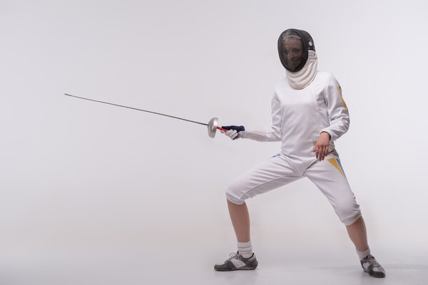 Молодая женщина занимается фехтованием
