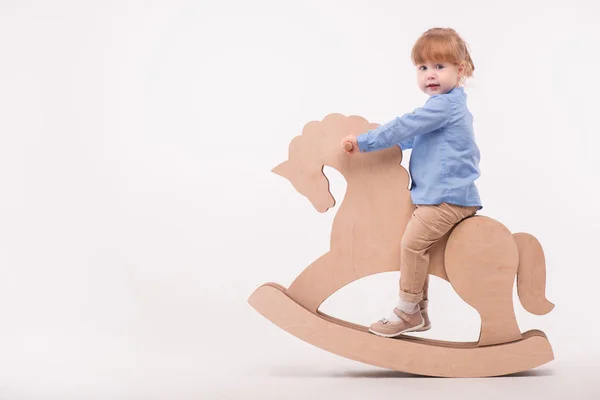 Criança com o cavalo de brinquedo — Fotografia de Stock