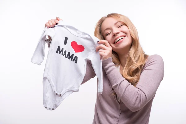 Young attractive woman holding babysuit I love mom isolated on w — Stock Photo, Image