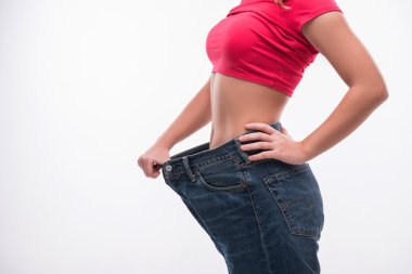 Başarılı kilo gösterilen büyük kot pantolon genç kadının ince bel