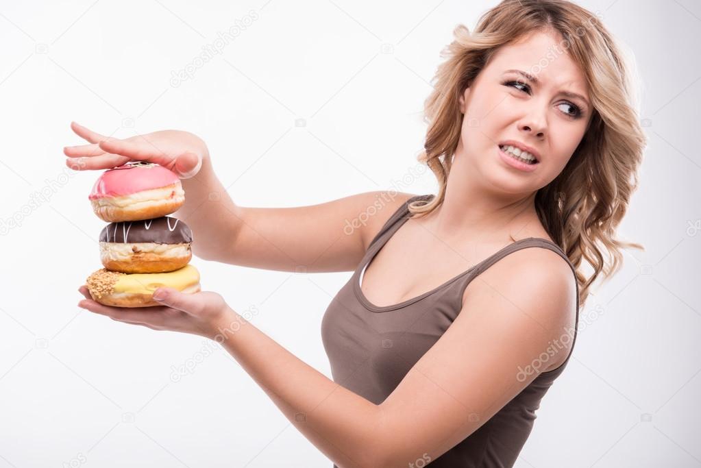 Young attractive woman with doughnuts isolated on white backgrou