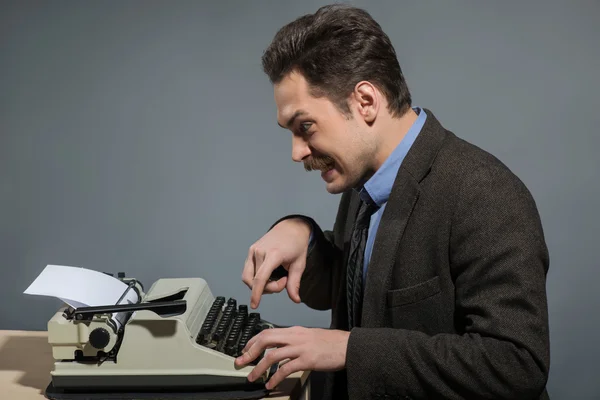 Feliz joven autor escribiendo en la máquina de escribir —  Fotos de Stock