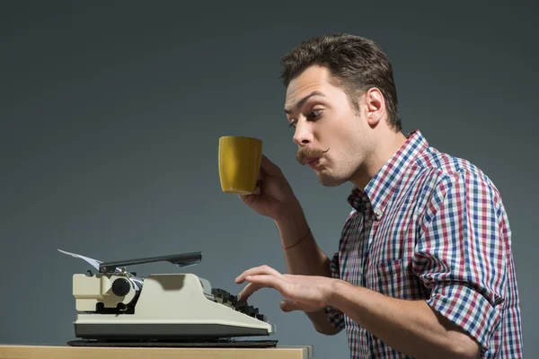Autor bebendo café na máquina de escrever — Fotografia de Stock