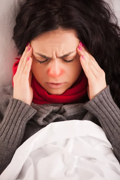 Young sick girl lying in bed with headache — Stock Photo, Image