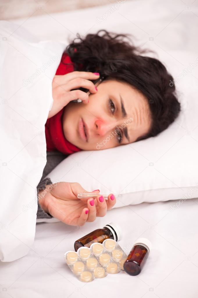 Frustrated woman lying in bed with pills