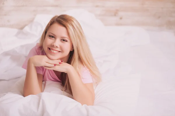 Schöne Frau wacht im Bett auf — Stockfoto