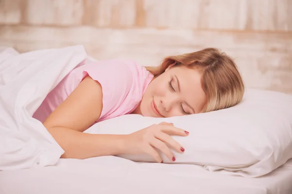 Genç kadın yatakta uyuyor. — Stok fotoğraf