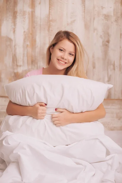 Mujer joven abrazando la almohada —  Fotos de Stock