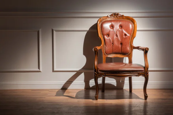 Коричневое классическое кресло к стене — стоковое фото