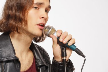 Genç yakışıklı şarkıcı holding mikrofon rock