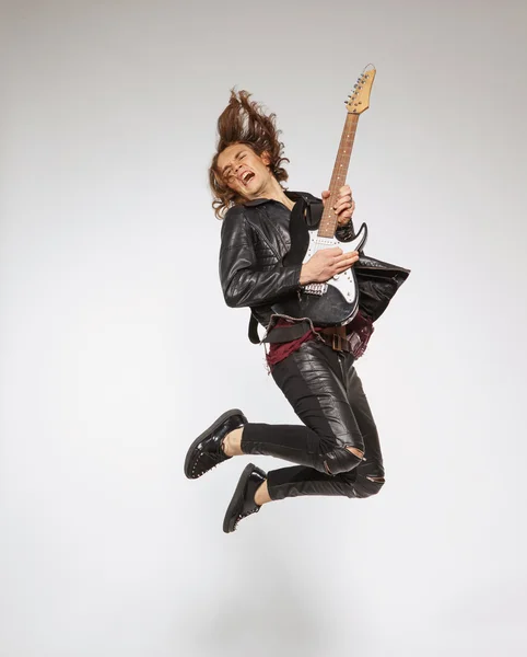 Young guitar player isolated on grey — Stock Photo, Image