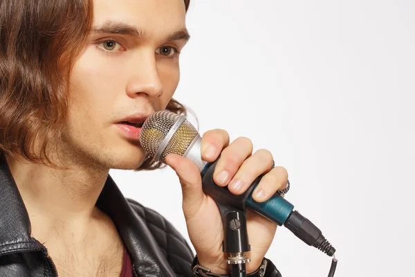 Young handsome rock singer holding microphone — Stock Photo, Image