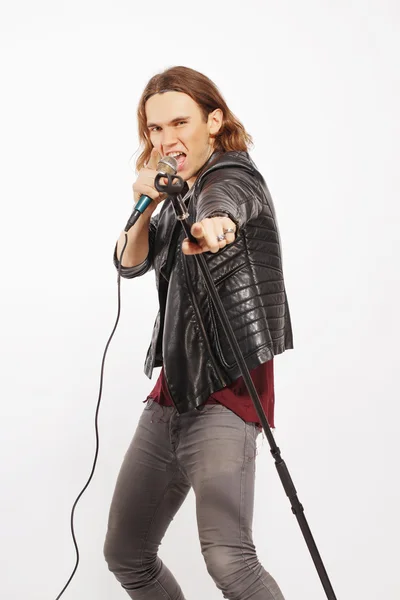 Jeune beau chanteur rock tenant un microphone — Photo