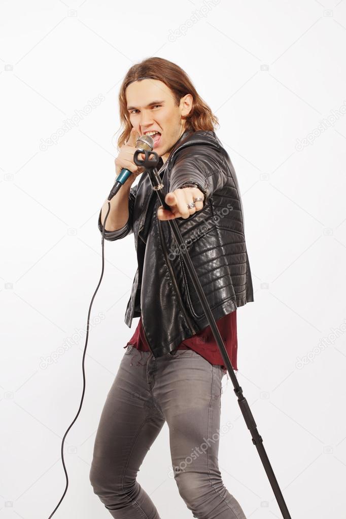 Young handsome rock singer holding microphone