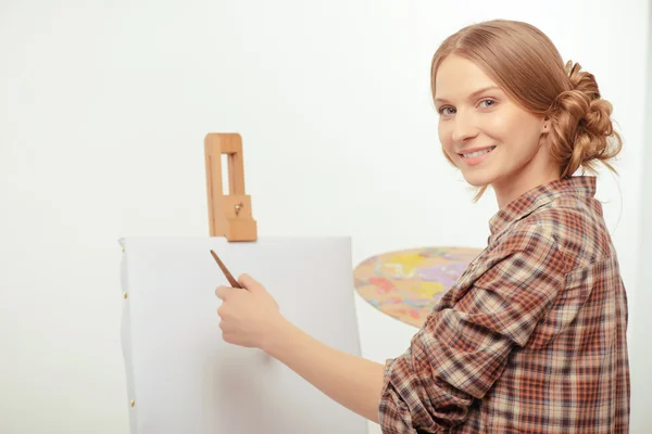 Jovem artista bonito posando com um cavalete de desenho e paleta — Fotografia de Stock