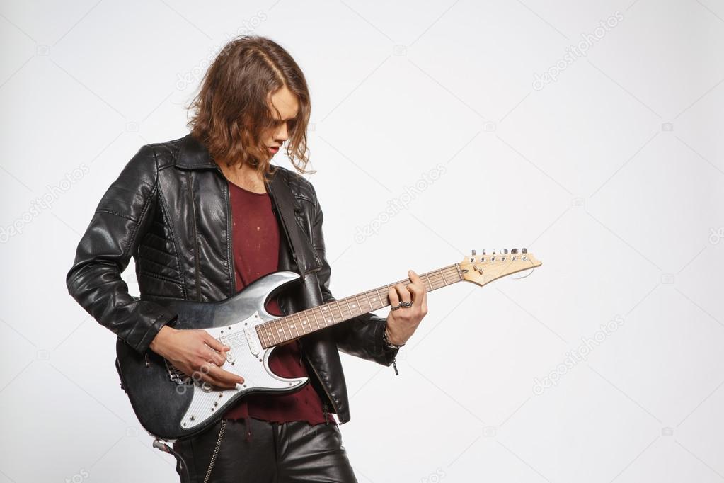Young guitar player isolated on grey