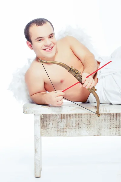 Pequeno anjo com um arco posando na mesa — Fotografia de Stock