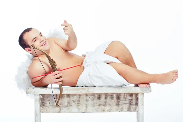 Pequeno anjo com um arco posando na mesa — Fotografia de Stock