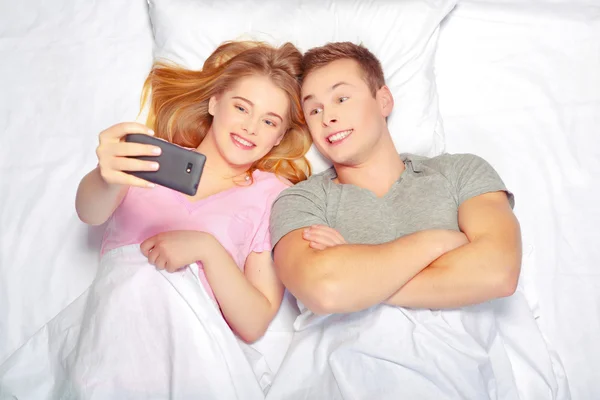 Beau jeune couple au lit — Photo