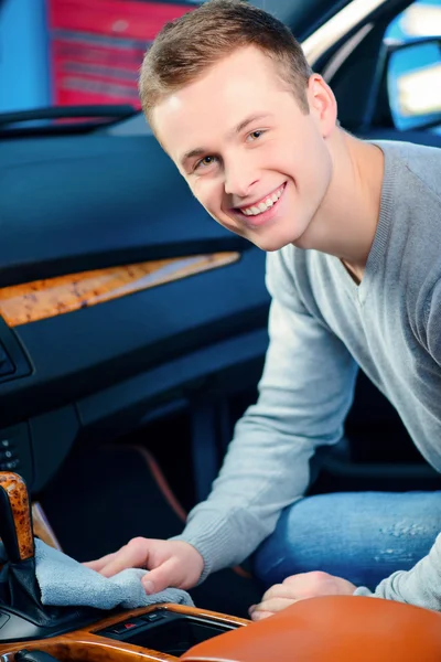 Handsome man cleaning his car