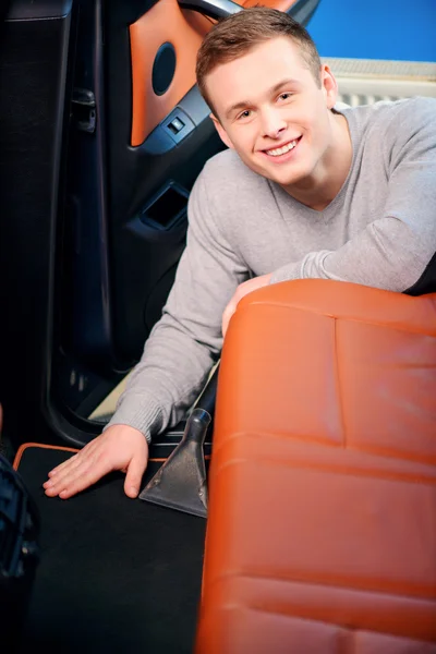 Hombre guapo aspirando su coche — Foto de Stock