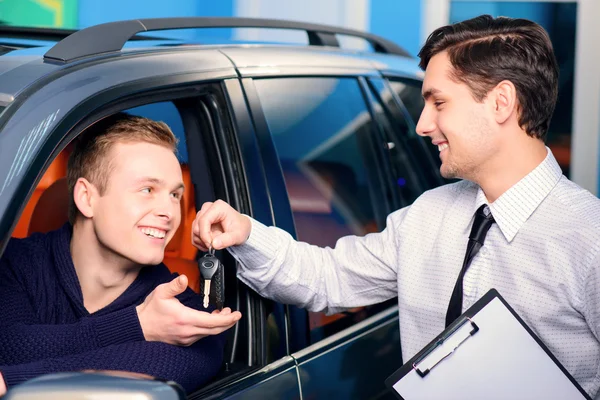 Sales manager giving key from the new car — Stock Photo, Image