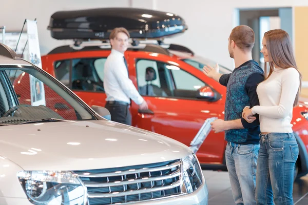Os clientes se comunicam com o consultor de vendas sobre o carro — Fotografia de Stock
