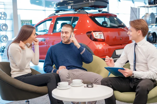Couple communicating with the salesman in showroom — Stock Photo, Image
