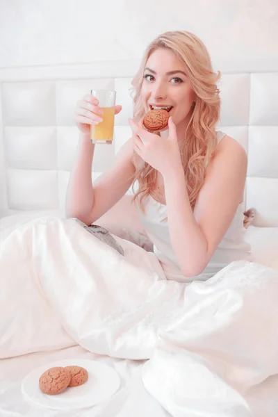Young attractive woman having breakfast in bedroom — Stock Photo, Image