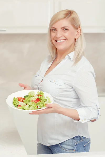 Mulher cozinha salada na cozinha — Fotografia de Stock