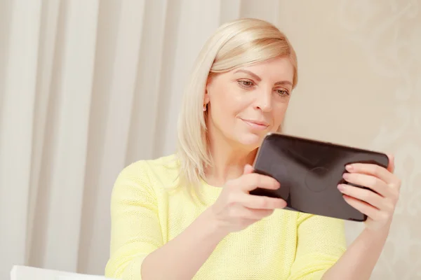 Mulher assistindo em seu dispositivo tablet — Fotografia de Stock