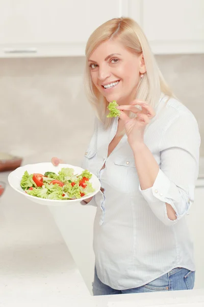 Femme cuisine salade dans la cuisine — Photo